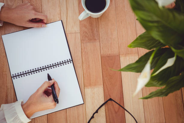 istock Cropped image of woman writing on notepad 661314492