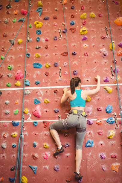 istock Woman climbing up rock wall 661318228