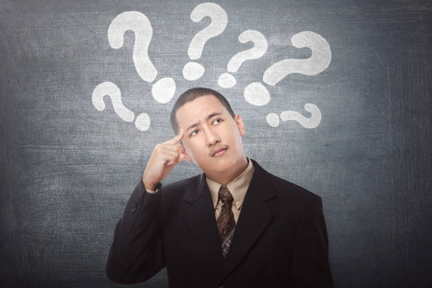 istock Young asian businessman confused with question marks above his head 661326906