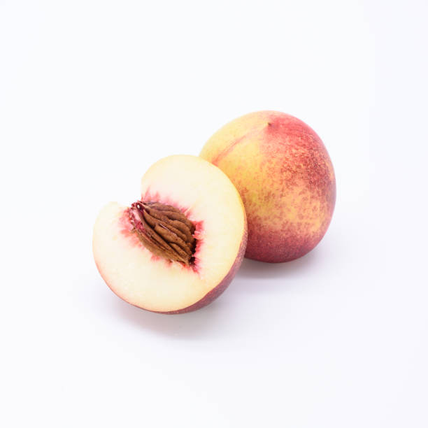 спелый весь белый персик и раскол изолированы на белом фоне. - nectarine white peach australia стоковые фото и изображения