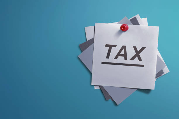 istock White note paper and written Tax for reminder 661348690
