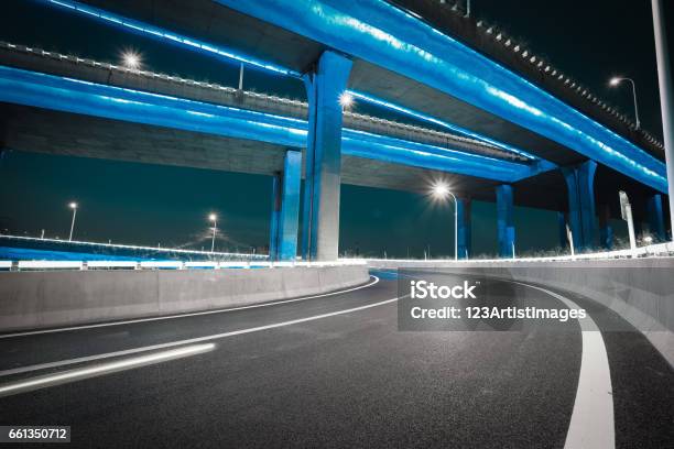 Empty Road Floor With City Viaduct Bridge Of Neon Lights Night Stock Photo - Download Image Now