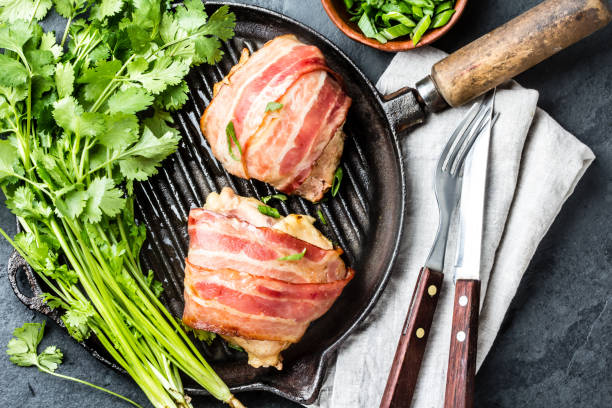istock Fried chicken wrapped in bacon on cast iron grill pan. Top view 661370706