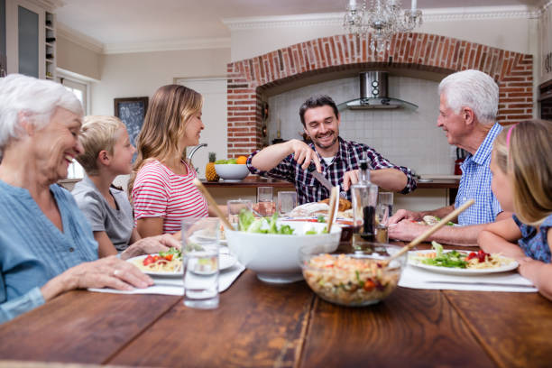 istock Man cutting roasted turkey while having meal with his family 661371970
