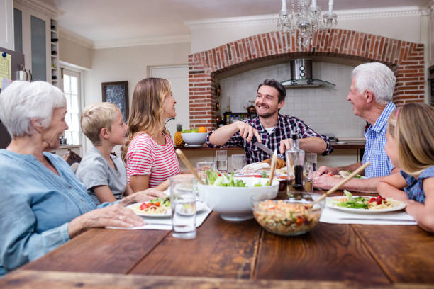 istock Man cutting roasted turkey while having meal with his family 661378760