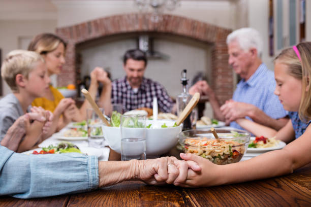 istock Multi-generation family praying before having meal 661384584