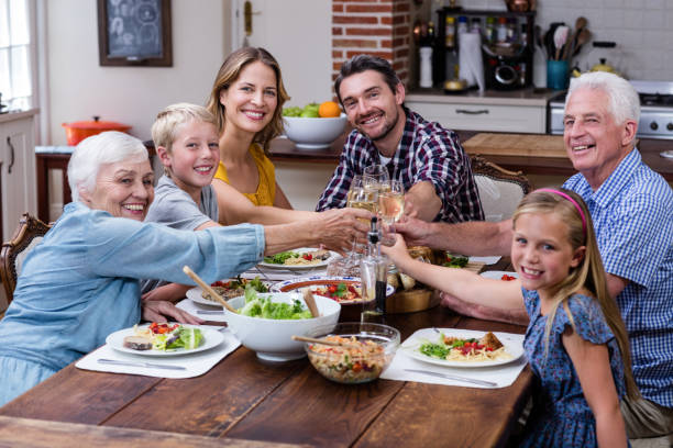 istock Multi-generation family toasting glass of wine while having meal 661400898
