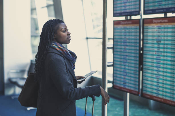 young woman at airport - arrival departure board travel business travel people traveling imagens e fotografias de stock