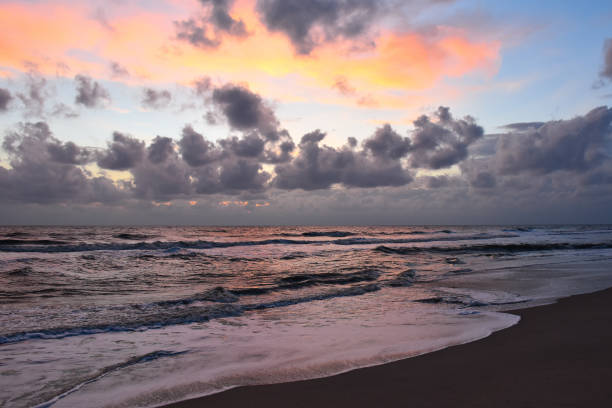 istock sunrise over the sea beach, cloudy 661409406