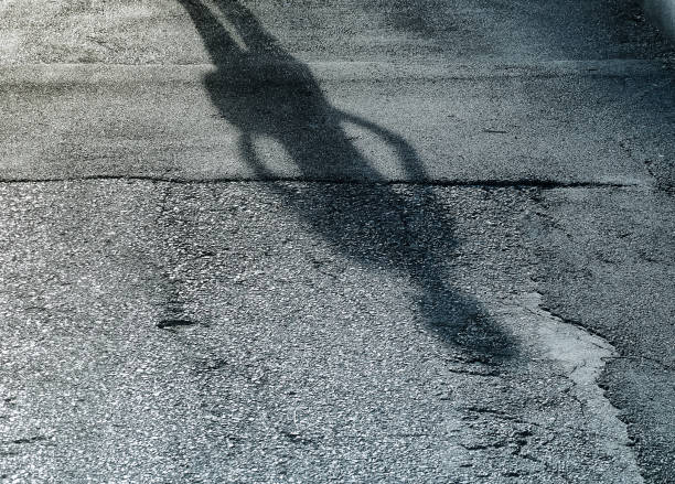 istock Shadow of a man on street concrete background 661410064