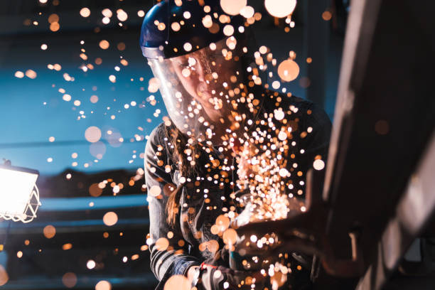 istock Sparks flying towards lens as a woman uses an angle grinder 661410242
