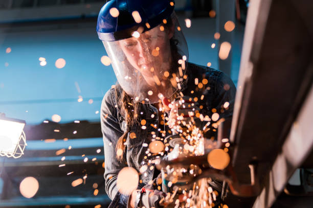 mujer con amoladora angular en taller - soldador fotografías e imágenes de stock