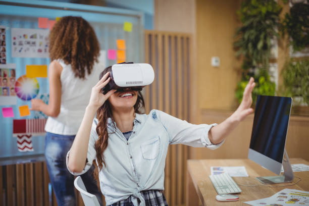 istock Female graphic designer using virtual reality headset with her colleague in background 661412410
