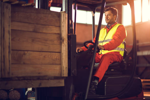 istock Manual worker driving forklift with palette in a warehouse. 661429374