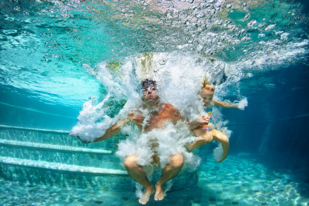 lycklig familj dykning under vattnet med kul i poolen - baby swim under water bildbanksfoton och bilder