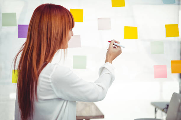 istock Attractive hipster woman writing on sticky notes 661435812
