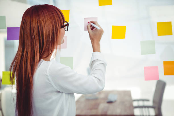 istock Attractive hipster woman writing on sticky notes 661436004