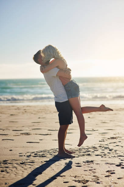 Shot of a loving couple sharing a kiss while spending time at the beach
