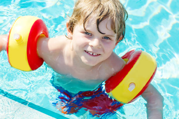 istock Happy little kid boy having fun in an swimming pool 661443952
