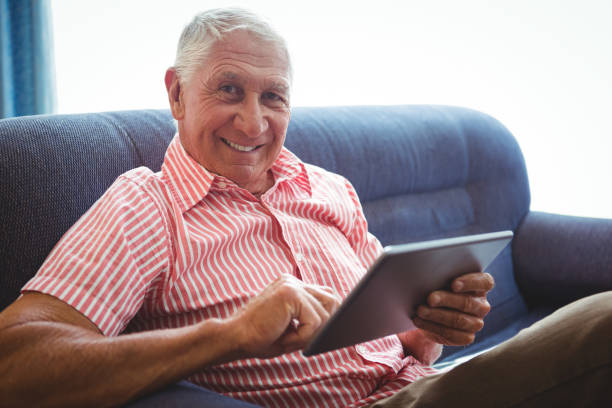 istock Senior man seated on a sofa looking at camera 661447088