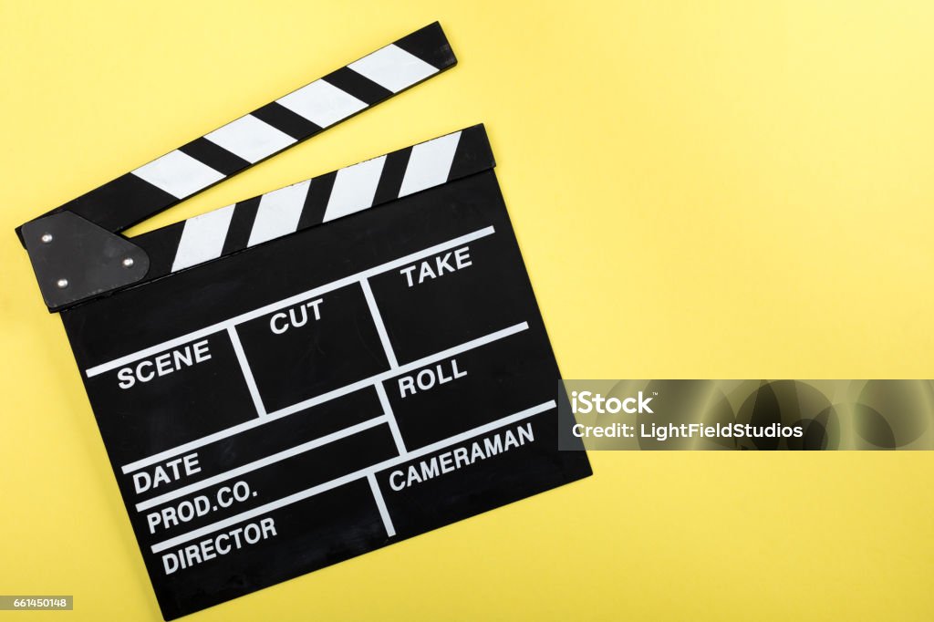 top view of movie clapper board on yellow Movie Ticket Stock Photo