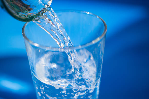 istock Water glass, pouring water, blue background, splashes 661450788