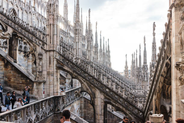 turisti ispezionano frammento di tetto decorato del duomo di milano - holidays and celebrations church wall italy foto e immagini stock