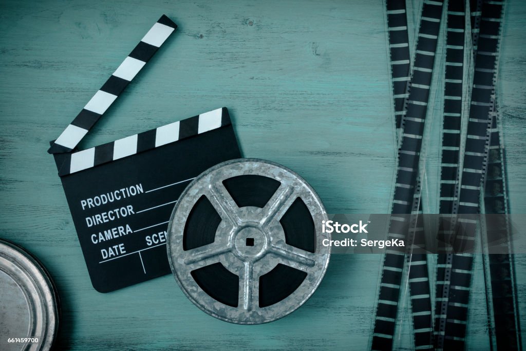 Clapperboards and the reel of film Clapperboards and the reel of film lie on a wooden board. Arts Culture and Entertainment Stock Photo