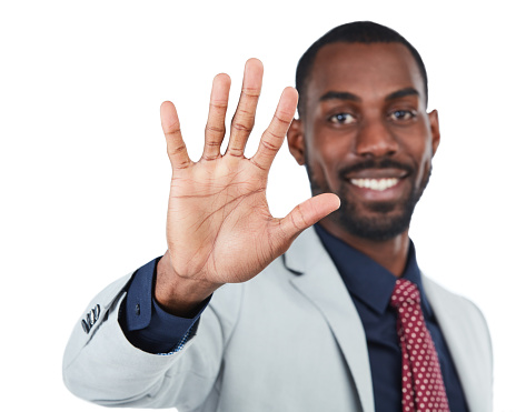 Studio shot of a young businessman showing the number five with his fingers against a white background