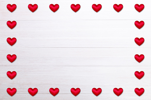 Red hearts. Valentines day. Symbol of love. Romantic greeting background. On white wooden table.