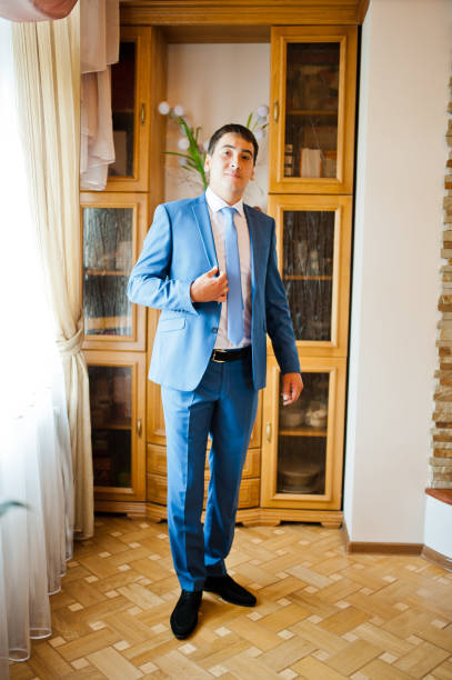 istock groom  gets dressed in formal wear and blue suit 661468088