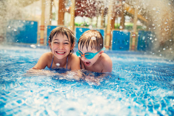 fratello e sorella che giocano nella piscina del resort. - cheerful swimming pool happiness resort swimming pool foto e immagini stock