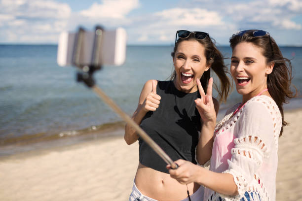 istock Two happy female friends taking selfie on beach 661478196