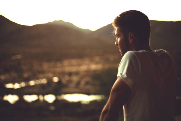 istock Handsome man gazing into horizon at sunset 661483026