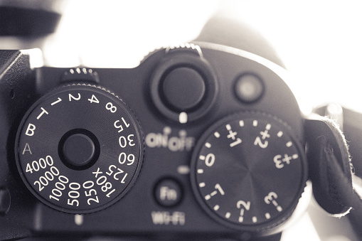 Close up macro image of the shutter speed dial on an old, vintage rangefinder camera. We can also see the bracketing exposure dial. Horizontal toned image with copy space.