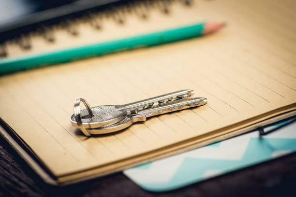 Couple of keys on the yellow notepad nearby green pencil. Memory concept