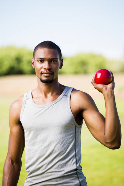 istock Male athlete holding shot put ball 661505660