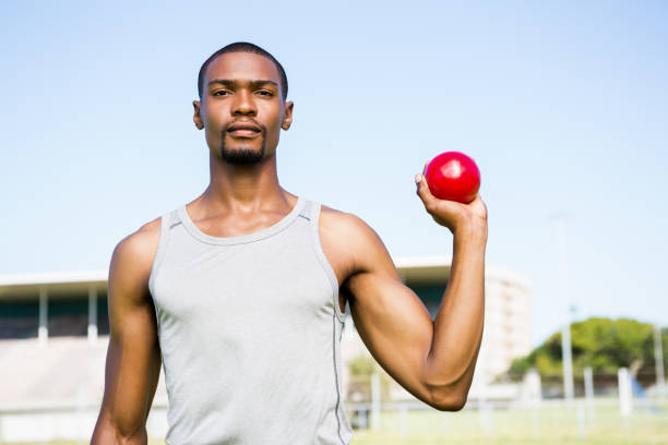 istock Male athlete holding shot put ball 661505774