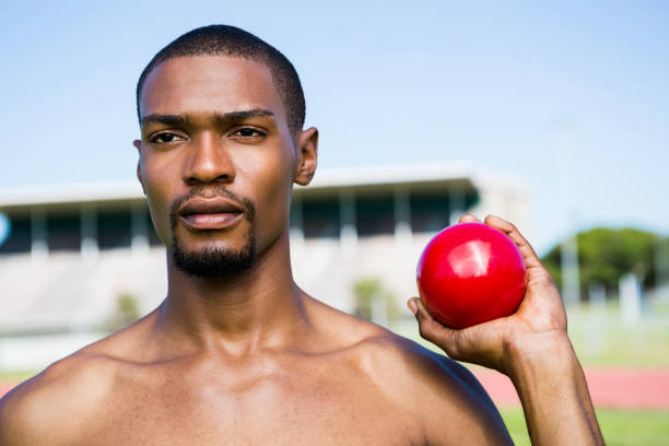 istock Male athlete holding shot put ball 661505912
