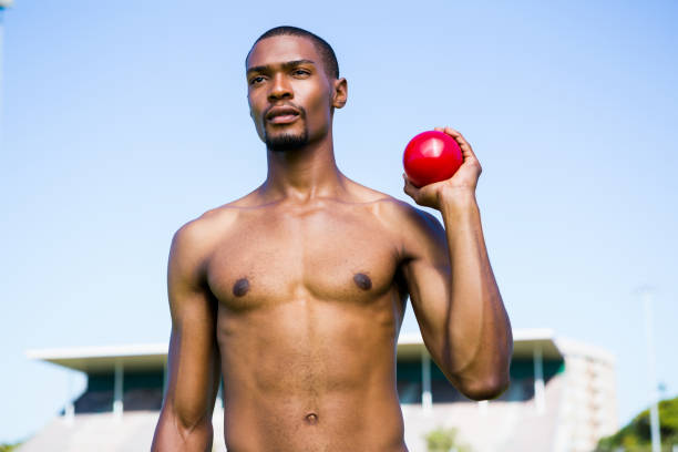 istock Male athlete holding shot put ball 661506164