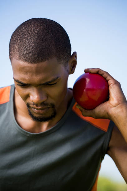 istock Male athlete holding shot put ball 661513002