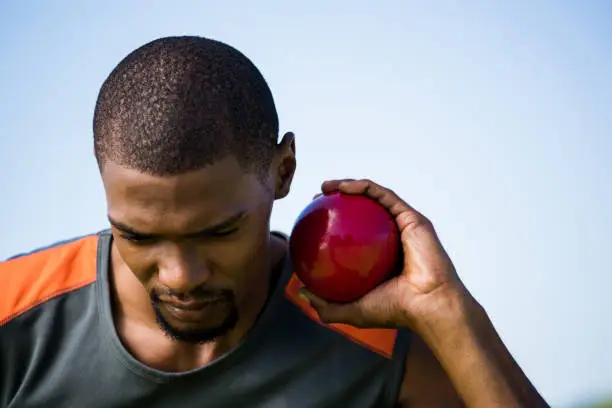 Photo of Male athlete holding shot put ball