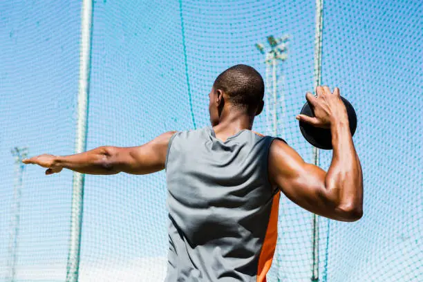 Rear view of athlete about to throw a discus in stadium