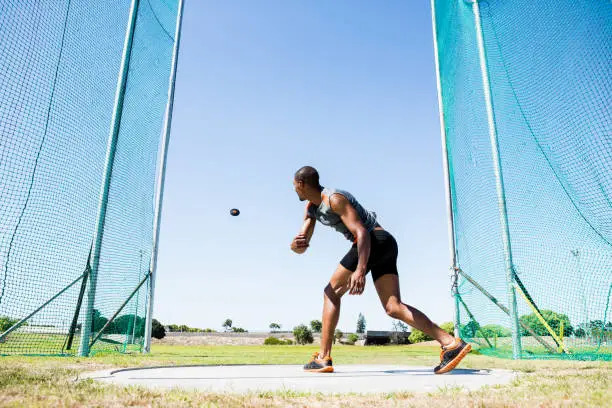 Athlete throwing discus in stadium during competition