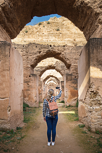 Teenager photographing an old moroccan granary in Meknes,Morocco.