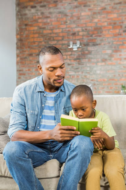 istock Father and son reading on the couch 661538040