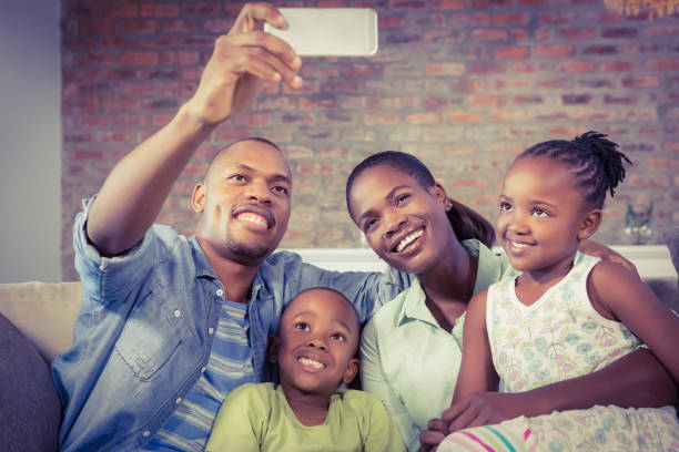 istock Happy family taking a selfie on the couch 661538842