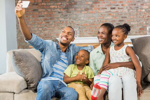 istock Happy family taking a selfie on the couch 661539064