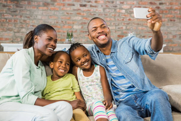 istock Happy family taking a selfie on the couch 661539436