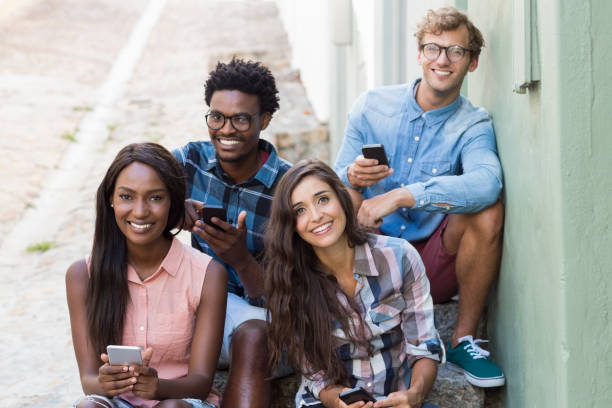 istock Friends sitting together using mobile phone 661539878